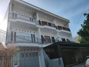 a white building with balconies on the side of it at RedDoorz near RS Islam Faisal Makassar in Makassar