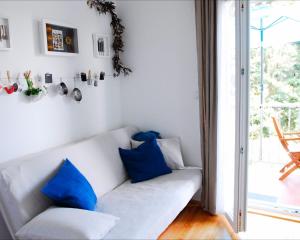 a living room with a white couch with blue pillows at Beachfront Apartment Mala Tereza in Split
