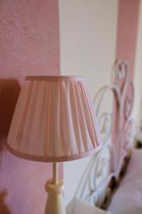 una lampada seduta accanto a un letto con testata di Agriturismo Percenna a Buonconvento