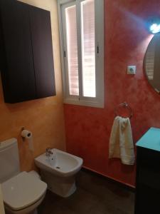 a bathroom with a toilet and a sink and a window at El Vergel del Piedra in Munébrega