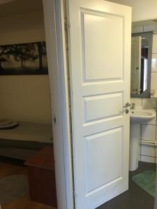 een witte deur in een badkamer met een wastafel bij Lägenhet med 2 sovrum och uteplats in Oxie