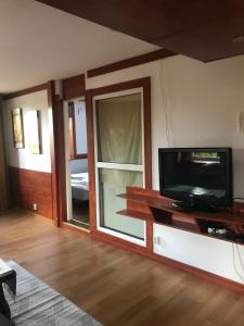 een woonkamer met een tv en een glazen schuifdeur bij Lägenhet med 2 sovrum och uteplats in Oxie