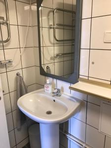 een badkamer met een witte wastafel en een spiegel bij Lägenhet med 2 sovrum och uteplats in Oxie