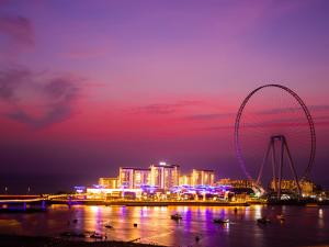 un perfil urbano con una noria por la noche en Roda Amwaj Suites Jumeirah Beach Residence, en Dubái