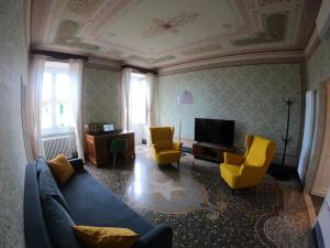 een woonkamer met een blauwe bank en 2 gele stoelen bij La Scialuppa in Camogli