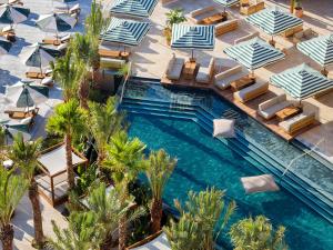 an overhead view of a swimming pool with chairs and umbrellas at Daios Cove in Agios Nikolaos