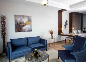 a living room with two blue couches and a table at Maslak Aparts in Istanbul