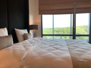a large white bed in a room with a large window at Maslak Aparts in Istanbul