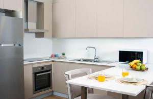 a white kitchen with a table with fruit on it at Maslak Aparts in Istanbul