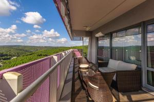 a balcony with wicker chairs and a view of the mountains at Maslak Aparts in Istanbul