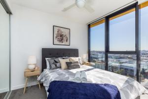 een slaapkamer met een bed en een groot raam bij KOZYGURU FORTITUDE VALLEY AMAZING VIEW 2BED APT + FREE PARKING QFV010 in Brisbane