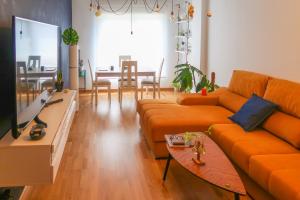 a living room with an orange couch and a table at Housingleon- Casa Oliva con Garaje in León