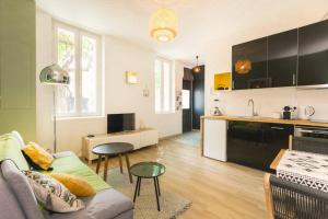a living room with a couch and a kitchen at Mini maison studio Ancienne Rénovée +Parking in Avignon