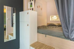 um quarto com uma cama e um frigorífico branco em Mini maison studio Ancienne Rénovée +Parking em Avignon