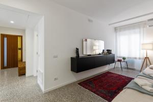 ein Wohnzimmer mit einem Sofa und einem TV an der Wand in der Unterkunft Inner City Apartments in Lecce