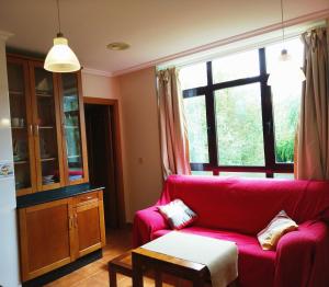 a living room with a red couch and a window at Apartamento Paseo Marítimo in O Vicedo