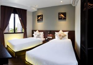 a bedroom with two beds and a window at Kimberley Hotel Georgetown in George Town +37 photos