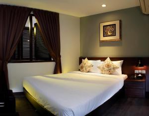 a bedroom with a large white bed with a window at Kimberley Hotel Georgetown in George Town