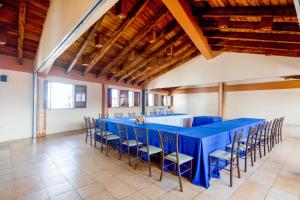 - długi niebieski stół i krzesła w pokoju z drewnianymi sufitami w obiekcie Capital O Hotel Central, Xalapa w mieście Xalapa