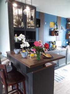 eine Küche mit einem Tisch mit Blumen darauf in der Unterkunft LES BIGORNEAUX in Saint-Suliac