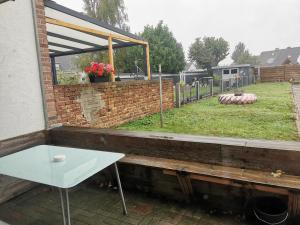 Ein weißer Tisch steht auf einer Terrasse mit Garten in der Unterkunft Ferienhaus Thalia in Übach-Palenberg