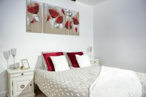 een witte slaapkamer met een bed met rode kussens bij Le petit Versailles T2 cosy proche Paris in Versailles