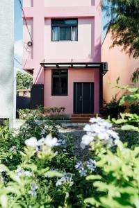 埔里鎮的住宿－以馬內利森林民宿，前面有鲜花的粉红色房子