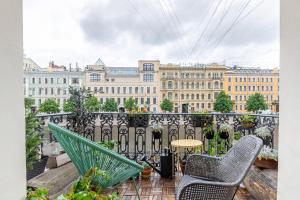 balcón con sillas, mesa y edificios en Soul Kitchen, en San Petersburgo