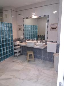 a bathroom with a sink and a large mirror at Big House Jerez in Jerez de la Frontera