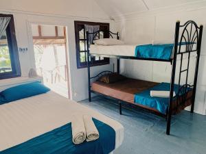 a room with two bunk beds and a window at Munchies Bungalows in Baan Tai