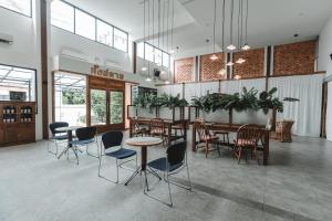 a lobby with tables and chairs in a building at The Chimes Chiangmai Old City in Chiang Mai