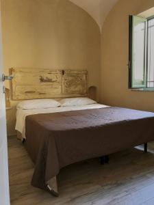 una camera con un grande letto con testiera in legno di Santa Venera Home a Marsala
