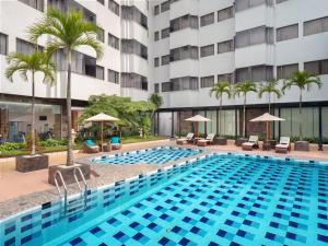 a swimming pool in front of a building at Radisson Medan in Medan