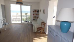 uma sala de estar com um sofá e uma mesa com um candeeiro em Villa T5 climatisée - Front de Mer - Narbonne Plage em Narbonne Plage