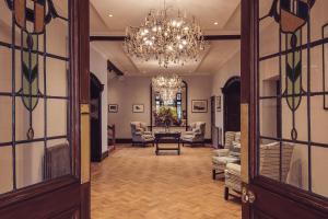 a hallway with a chandelier and a living room at Lakeside Hotel and Spa in Newby Bridge