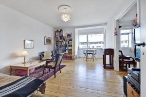 Stille og hyggelig lejlighed في كوبنهاغن: غرفة معيشة مع سرير وغرفة طعام