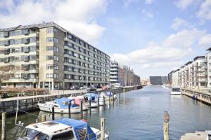 Stille og hyggelig lejlighed في كوبنهاغن: مجموعة قوارب مرساة في نهر مع مباني