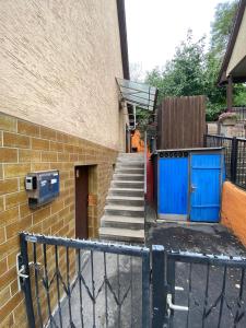 a building with a staircase with blue doors and a fence at Einfaches Haus mit Privatzimmern und Gemeinschaftsräumen in Heilbronn