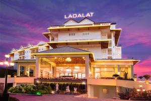 a large white building with a sunset in the background at LADALAT Hotel in Da Lat