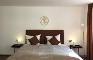1 dormitorio con 1 cama grande con almohadas y reloj en Appartements am Schloss en Tübingen