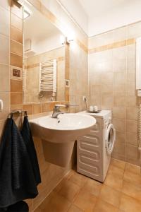 een badkamer met een wastafel en een wasmachine bij Negroni Apartments Stare Miasto in Krakau