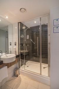 ein Bad mit einer Dusche und einem Waschbecken in der Unterkunft Holiday Inn Express Preston South, an IHG Hotel in Preston