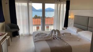 a hotel room with a bed with a view of the ocean at Hotel Rosa in Baveno