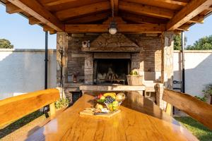 a wooden table in front of a stone fireplace at Holiday Home Kerniat in Pula