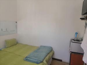 Habitación pequeña con cama con manta verde en LEONE PARIS, en Windhoek
