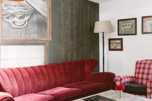 a living room with a red couch and a chair at Aethos Milan in Milan