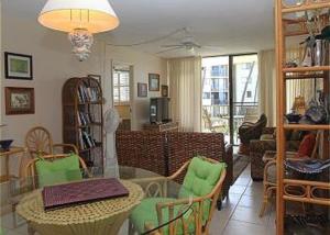 a living room with a glass table and green chairs at Kanai A Nalu Resort 205 in Wailuku