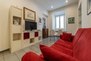 un salon avec un canapé rouge et une télévision dans l'établissement Porta Pia & Villa Torlonia Apartment with Balcony, à Rome