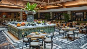 a restaurant with tables and chairs and a bar at Hotel Indonesia Kempinski Jakarta in Jakarta