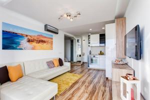 ein Wohnzimmer mit einem weißen Sofa und einem TV in der Unterkunft Marlin I Puerto del Carmen in Puerto del Carmen